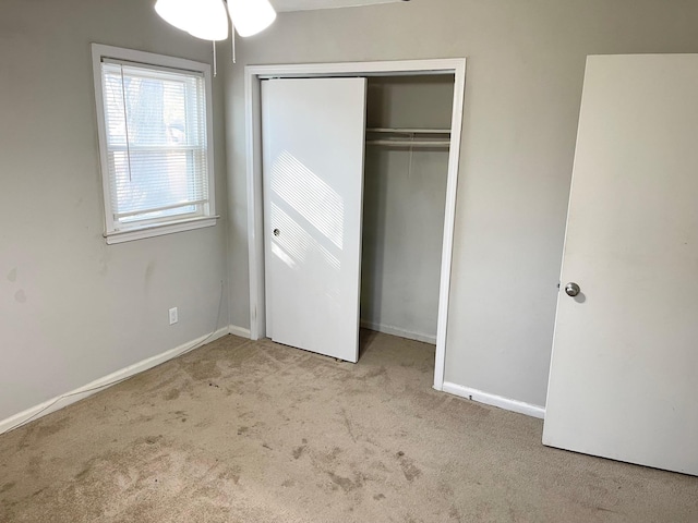 unfurnished bedroom featuring carpet flooring, baseboards, and a closet