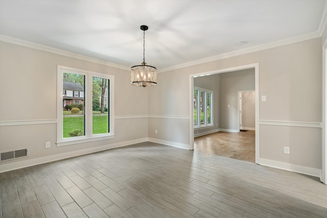 unfurnished room featuring visible vents, ornamental molding, wood finished floors, an inviting chandelier, and baseboards