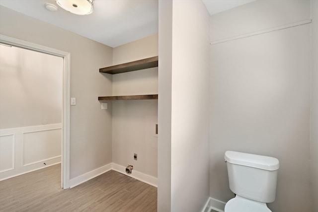 laundry area with a wainscoted wall, laundry area, wood finished floors, a decorative wall, and hookup for an electric dryer