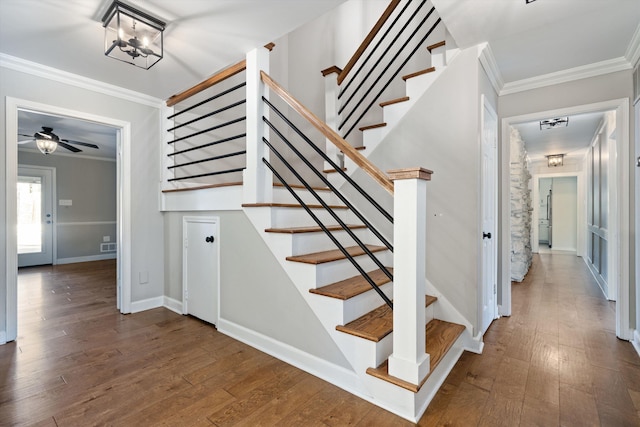 stairs featuring baseboards, ornamental molding, and hardwood / wood-style flooring