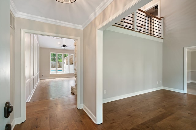 interior space featuring baseboards, dark wood-type flooring, and ornamental molding