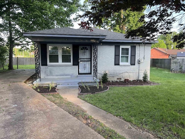 bungalow with a front yard, fence, brick siding, and crawl space