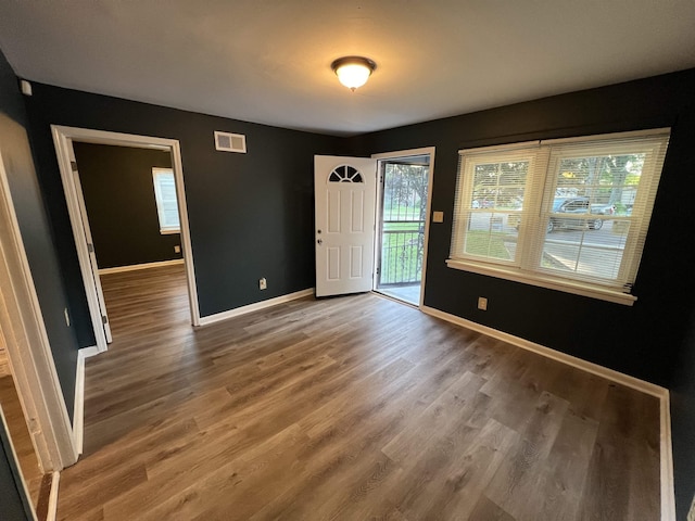 unfurnished room with visible vents, baseboards, and wood finished floors