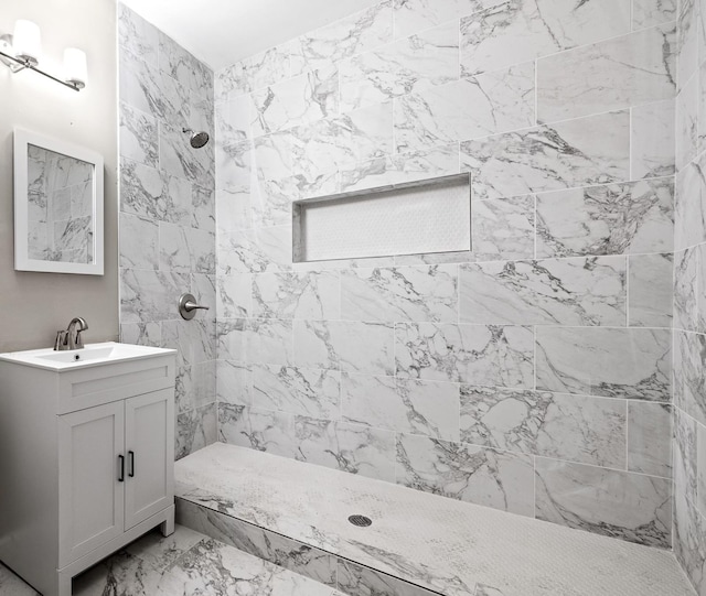 bathroom featuring vanity, marble finish floor, and tiled shower