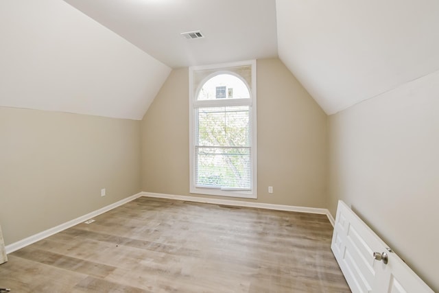 bonus room with lofted ceiling, light wood-style floors, visible vents, and baseboards