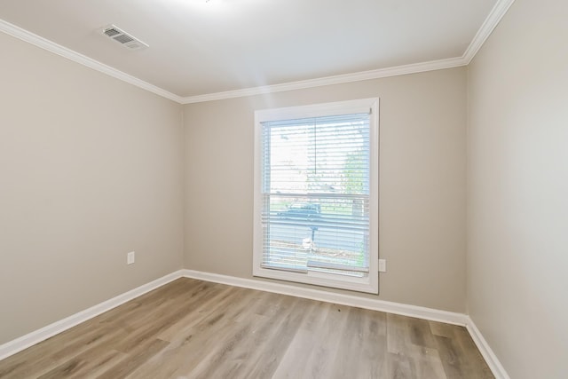 empty room featuring visible vents, baseboards, light wood-style floors, and ornamental molding