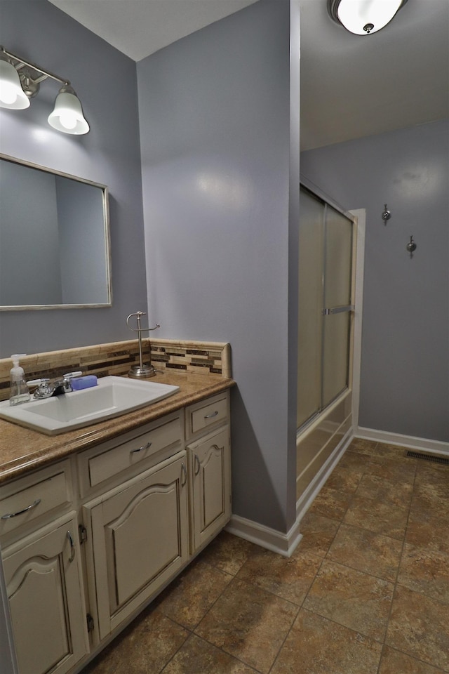 134 Willow Creek Dr, Ripley, TN 38063 - full bath with decorative backsplash, baseboards, bath / shower combo with glass door, and vanity