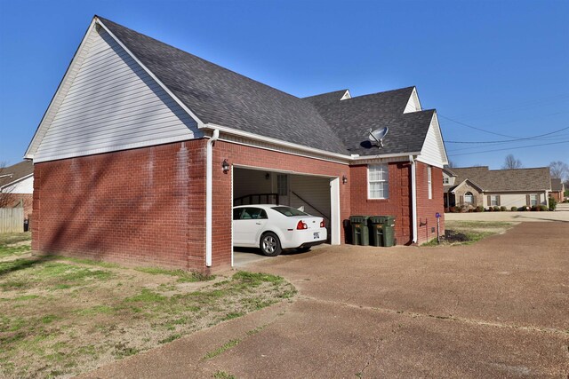 134 Willow Creek Dr, Ripley, TN 38063 - view of side of home with brick siding, a garage, concrete driveway, and roof with shingles