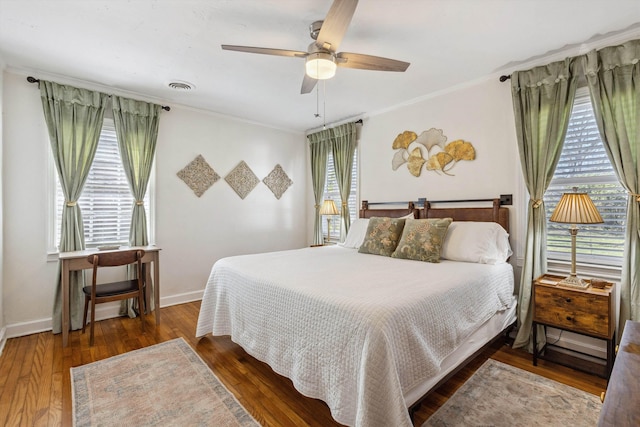 bedroom with visible vents, crown molding, ceiling fan, baseboards, and hardwood / wood-style floors