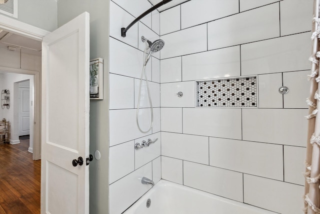 full bath featuring visible vents, wood finished floors, and shower / washtub combination