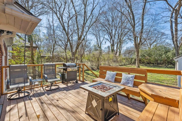 wooden deck with grilling area and an outdoor fire pit