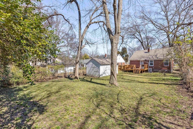 view of yard with a deck, an outbuilding, and a storage unit