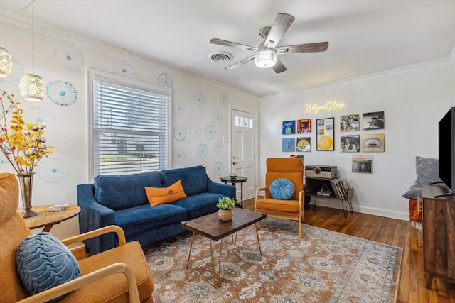 living area featuring crown molding, a ceiling fan, visible vents, and wood-type flooring