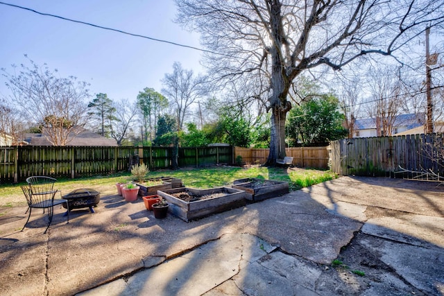 view of patio / terrace with a fire pit, a fenced backyard, and a garden