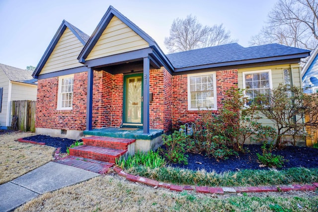 bungalow-style house with crawl space, brick siding, a shingled roof, and fence