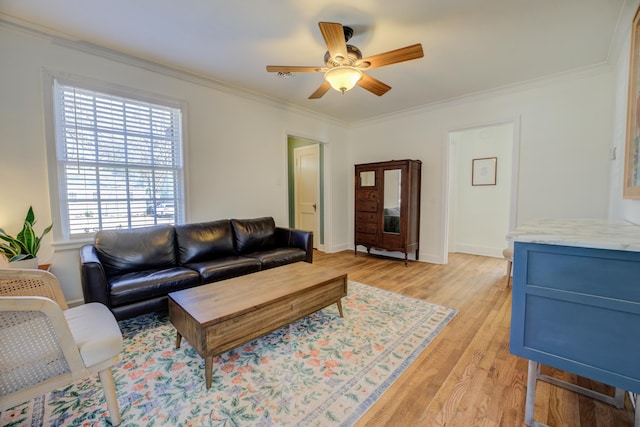 living room featuring ceiling fan, baseboards, light wood-style floors, and ornamental molding