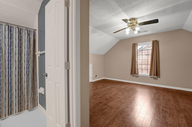 bonus room featuring visible vents, vaulted ceiling, wood finished floors, a textured ceiling, and a ceiling fan