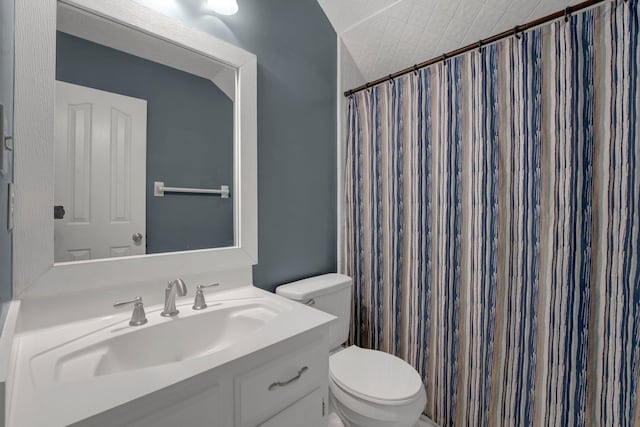 bathroom featuring a shower with shower curtain, toilet, and vanity