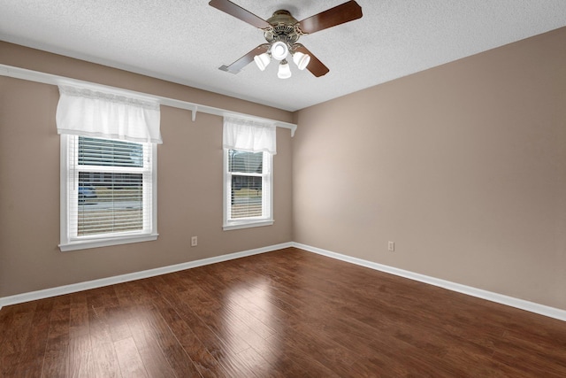 unfurnished room featuring dark wood finished floors, a ceiling fan, baseboards, and a textured ceiling