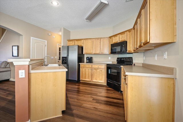 kitchen featuring black appliances, a sink, a textured ceiling, dark wood finished floors, and arched walkways