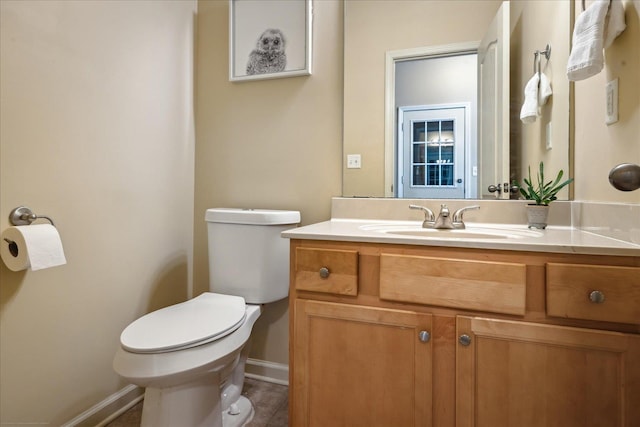 bathroom with baseboards, toilet, and vanity