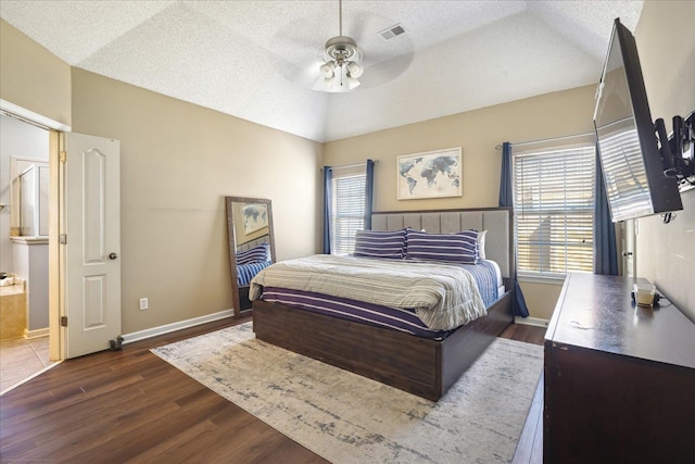 bedroom with visible vents, multiple windows, lofted ceiling, and wood finished floors