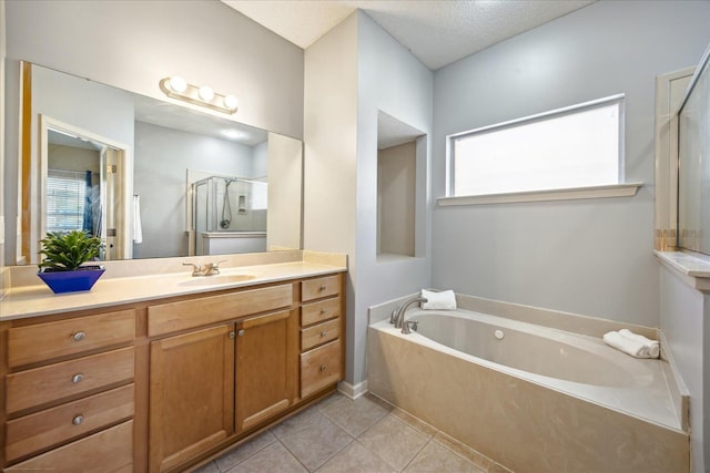 full bathroom featuring vanity, a garden tub, a shower stall, a textured ceiling, and tile patterned floors