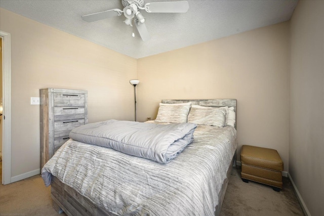 bedroom featuring a textured ceiling, baseboards, carpet, and a ceiling fan