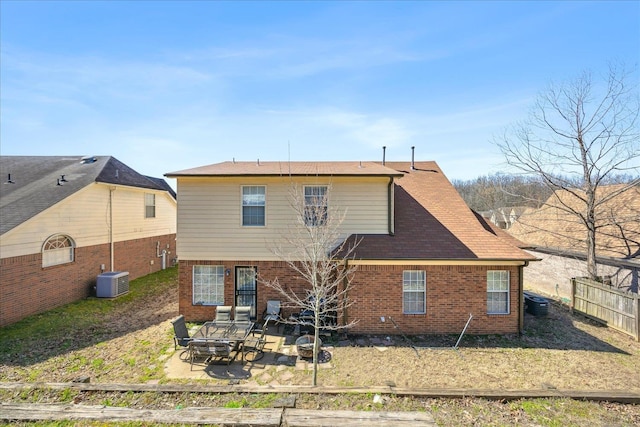 rear view of property featuring brick siding, a patio area, and fence