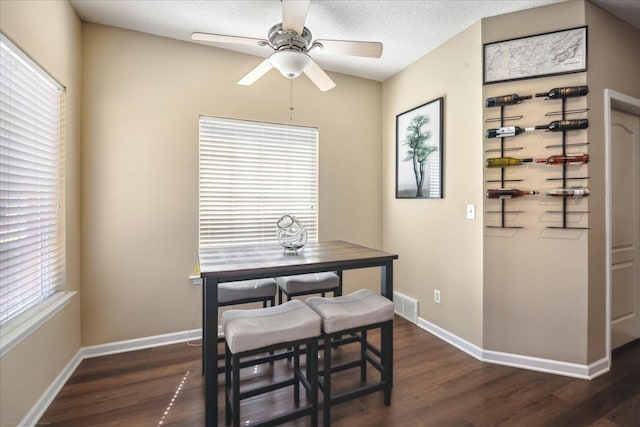 dining space with visible vents, a textured ceiling, baseboards, and dark wood-style flooring