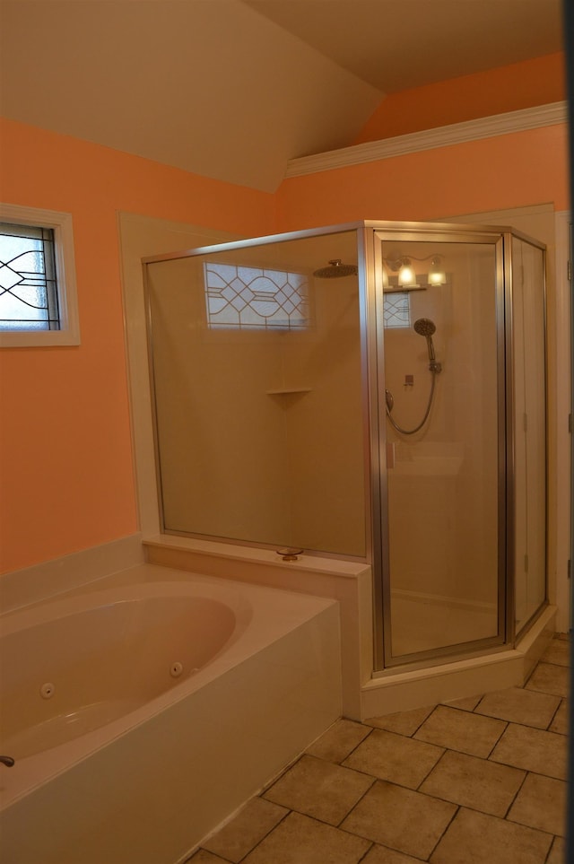 bathroom with a jetted tub, vaulted ceiling, a shower stall, and tile patterned flooring