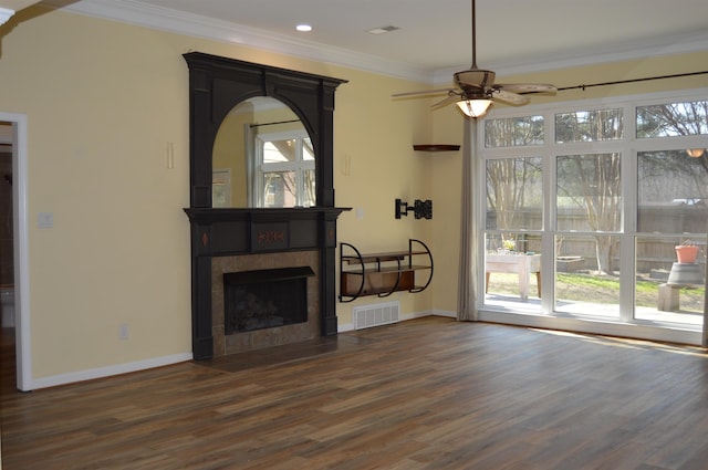 unfurnished living room featuring visible vents, plenty of natural light, a tile fireplace, and ornamental molding