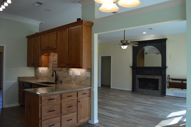 kitchen with visible vents, ornamental molding, a tile fireplace, and a sink