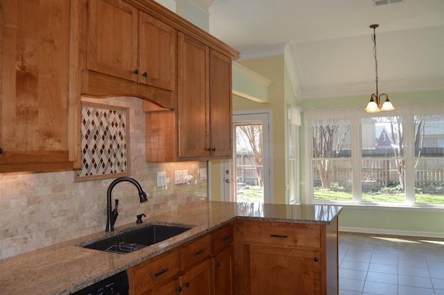 kitchen with a sink, decorative backsplash, a wealth of natural light, and crown molding