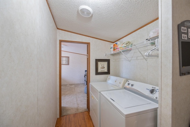 clothes washing area featuring visible vents, crown molding, washer and clothes dryer, laundry area, and a textured ceiling