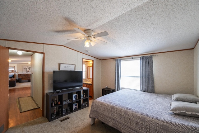 carpeted bedroom with a textured ceiling, lofted ceiling, visible vents, and ornamental molding