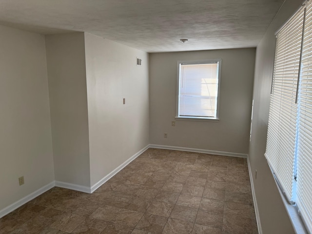 empty room with baseboards and a textured ceiling