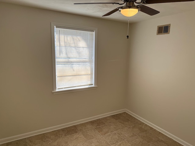 spare room with visible vents, baseboards, and a ceiling fan