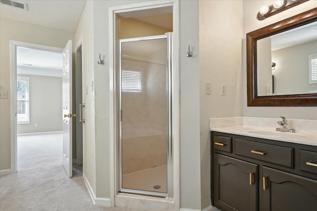 bathroom with visible vents, a shower stall, vanity, and baseboards