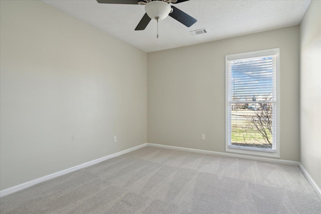 spare room with baseboards, visible vents, and light carpet