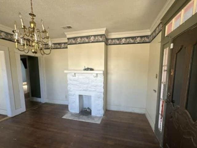 unfurnished living room featuring baseboards, wood finished floors, an inviting chandelier, and ornamental molding