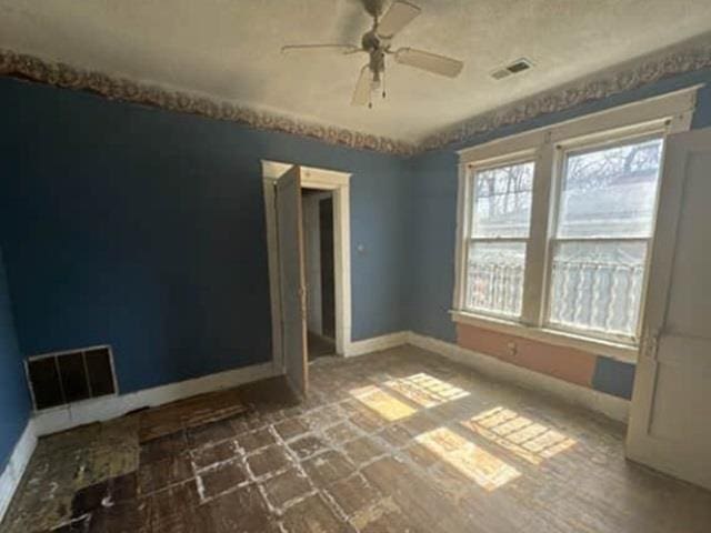 spare room with visible vents, baseboards, and a ceiling fan