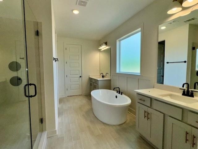5876 Milton Wilson Blvd, Arlington, TN 38002 - full bathroom with a sink, wood finished floors, visible vents, a soaking tub, and a stall shower