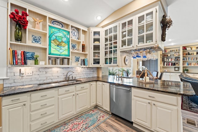 kitchen featuring a sink, dishwasher, dark stone counters, light wood-type flooring, and open shelves