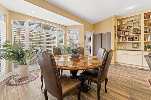 dining room featuring vaulted ceiling, recessed lighting, and light wood finished floors