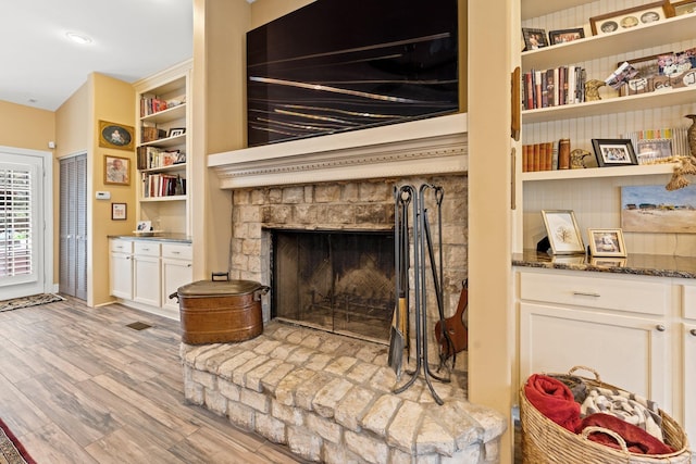 interior details with visible vents, a fireplace, and wood finished floors