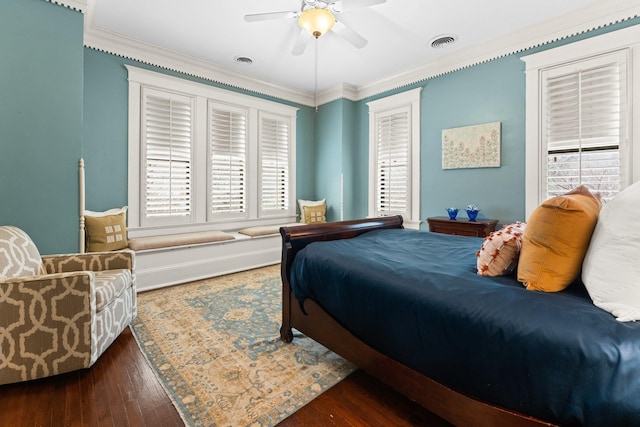 bedroom featuring ceiling fan, visible vents, wood finished floors, and ornamental molding