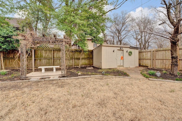 view of yard featuring a storage shed, an outbuilding, a fenced backyard, and a patio area