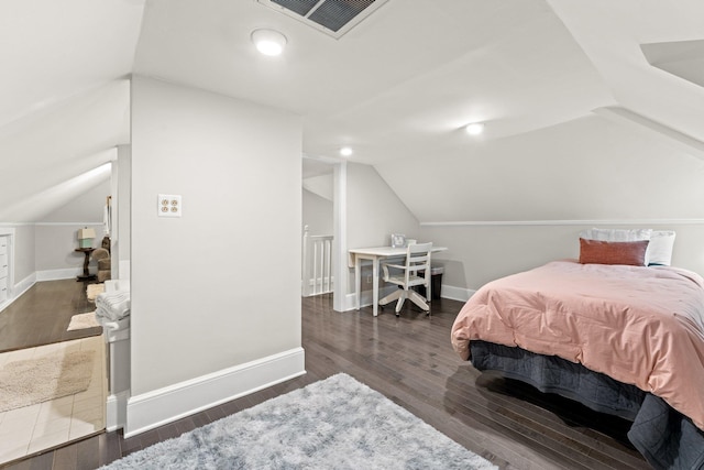 bedroom featuring visible vents, baseboards, lofted ceiling, and wood finished floors