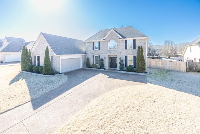 view of front of property featuring brick siding, an attached garage, driveway, and fence